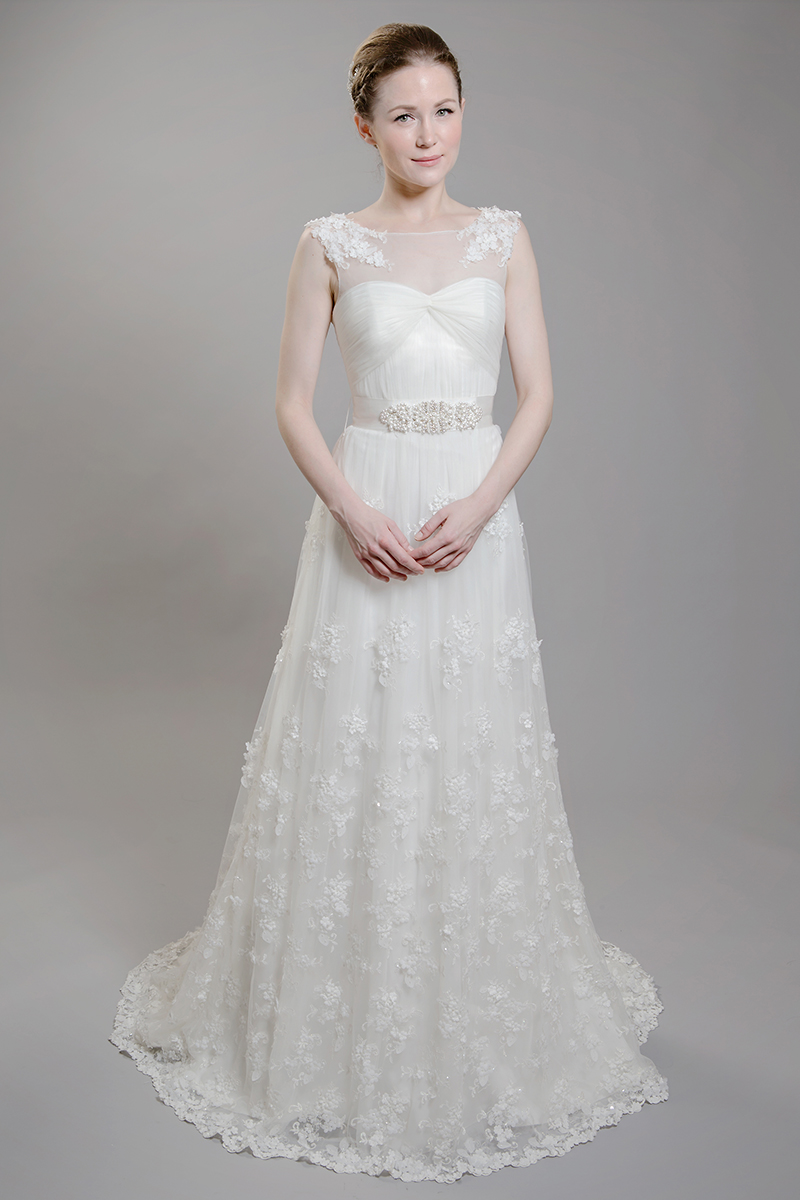 F1601 is the darling of the season! It is the first design created with Spring 2016 in mind. The soft ivory tulle is enhanced with handmade, beaded flowers and an illusion neckline.