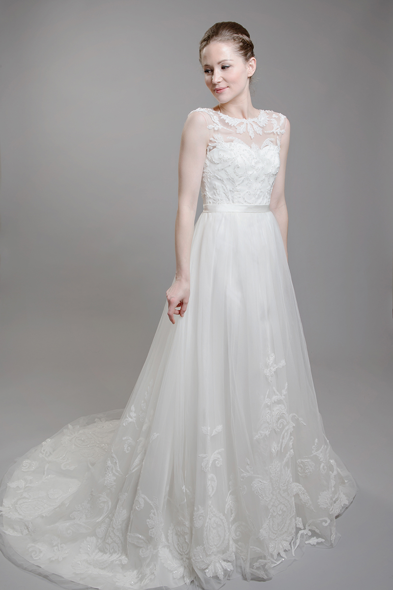 The sweet tulle and beaded lace style of F1614  has a lovely attached belt and an elegant statement illusion neckline. It is available in both ivory and ivory over champagne.